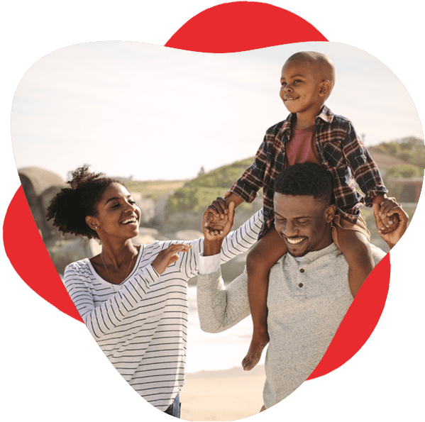 Young black family walks outside, the father carrying his son on his shoulders while mom reaches up for him