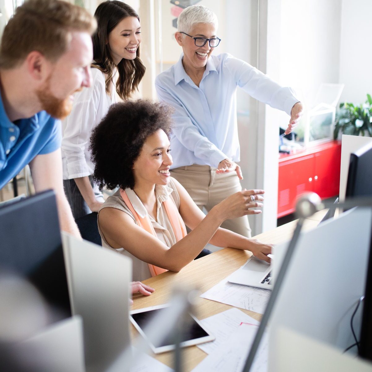 Diverse group of colleagues collaborating on one desktop computer